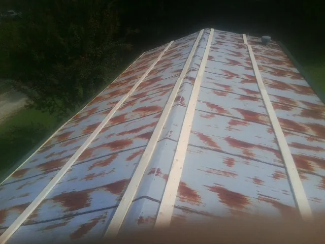 Rusted metal roof panels with new wood purlins before replacement — Storm Damage Roof Repair in Myakka City by Roofing Brothers